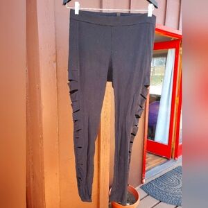 Bebe size L stretch pants with cut-out on legs from hip to ankle